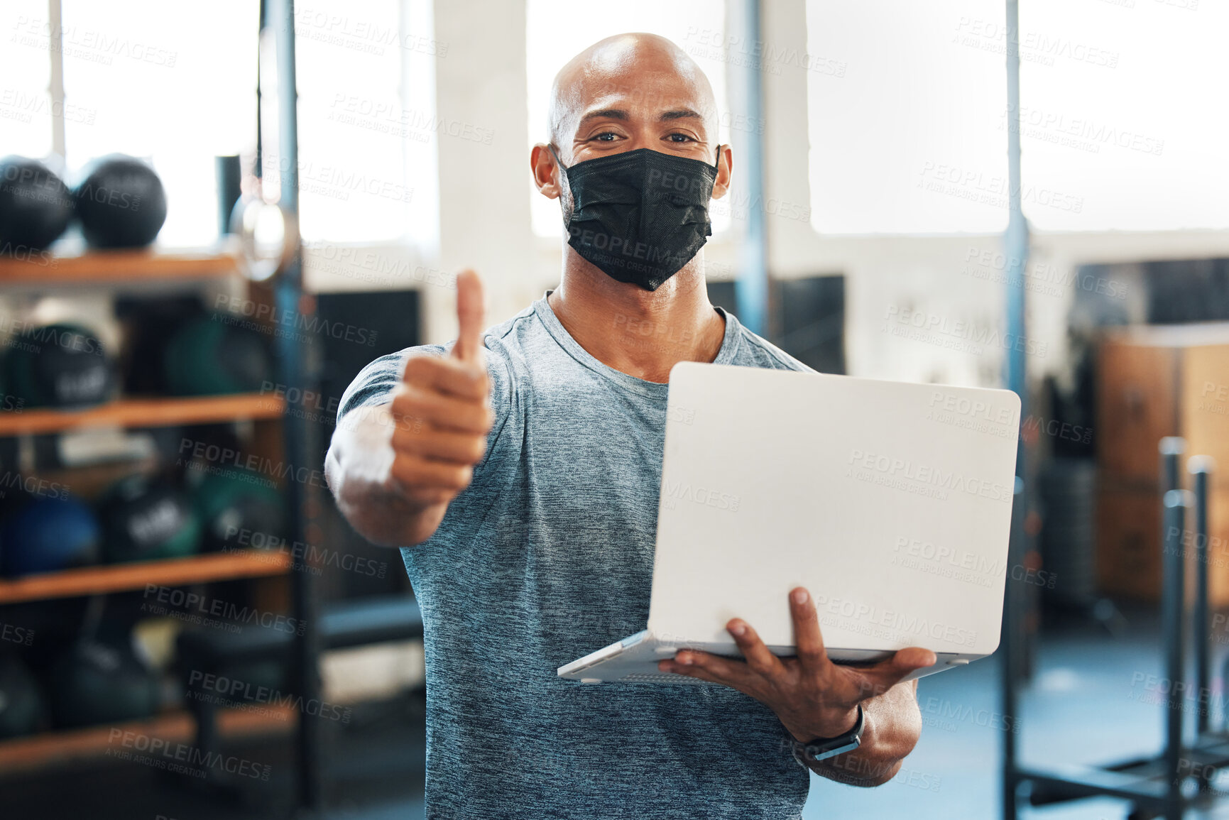 Buy stock photo Laptop, portrait and thumbs up with fitness man in mask at gym for motivation, success or support. Computer, emoji and exercise with coach or personal trainer in health club for goals and target