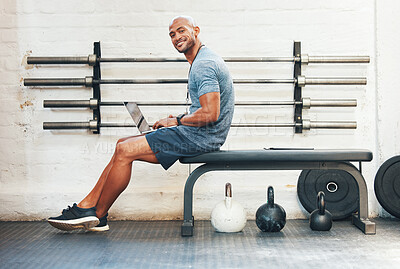 Buy stock photo Portrait of a muscular young man using a laptop in a gym