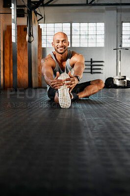 Buy stock photo Shot of a young man stretching his legs before a workout
