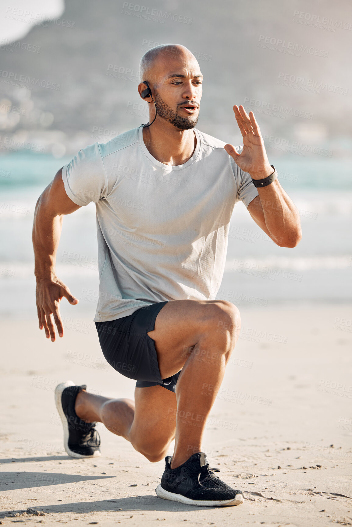 Buy stock photo Wellness, warm up and beach with lunge of African man, fitness and running with stretch for leg muscle. Earphones, workout and runner with music, sea and outdoor for marathon training by ocean