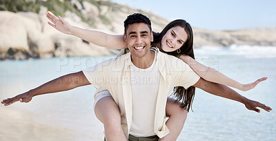 Buy stock photo Couple, piggy back and portrait at beach for vacation with stretching arms, airplane and sign with bonding. Man, woman and happy for interracial love with care, playful and holiday by sea in Greece