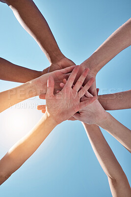 Buy stock photo People, team and hands together below for unity, collaboration or synergy on a blue sky background. Closeup or low angle of group or community piling or stacking in solidarity for join or mission