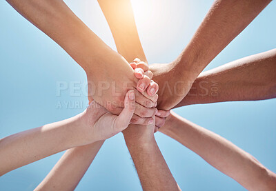 Buy stock photo People, teamwork and hands together below for unity, collaboration or synergy on a blue sky background. Closeup or low angle of group or community in trust or solidarity for care, support or mission