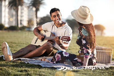 Buy stock photo Picnic, date and man with guitar for romance, love and anniversary in Puerto Rico. Couple, happy and music in outing on grass for summer, relax or happiness together at sunset with instrument in park