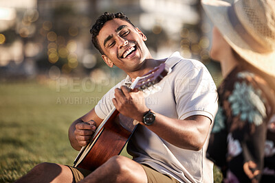 Buy stock photo Picnic, date and man with guitar for happiness, love and anniversary in Puerto Rico. Couple, happy and music in outing on grass for summer, relax or romance together at sunset with instrument in park