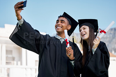 Buy stock photo Shot of two young students taking selfies on graduation day