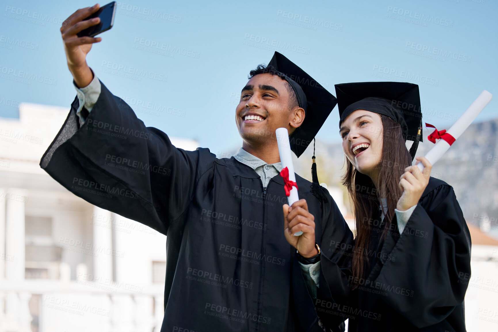 Buy stock photo Shot of two young students taking selfies on graduation day