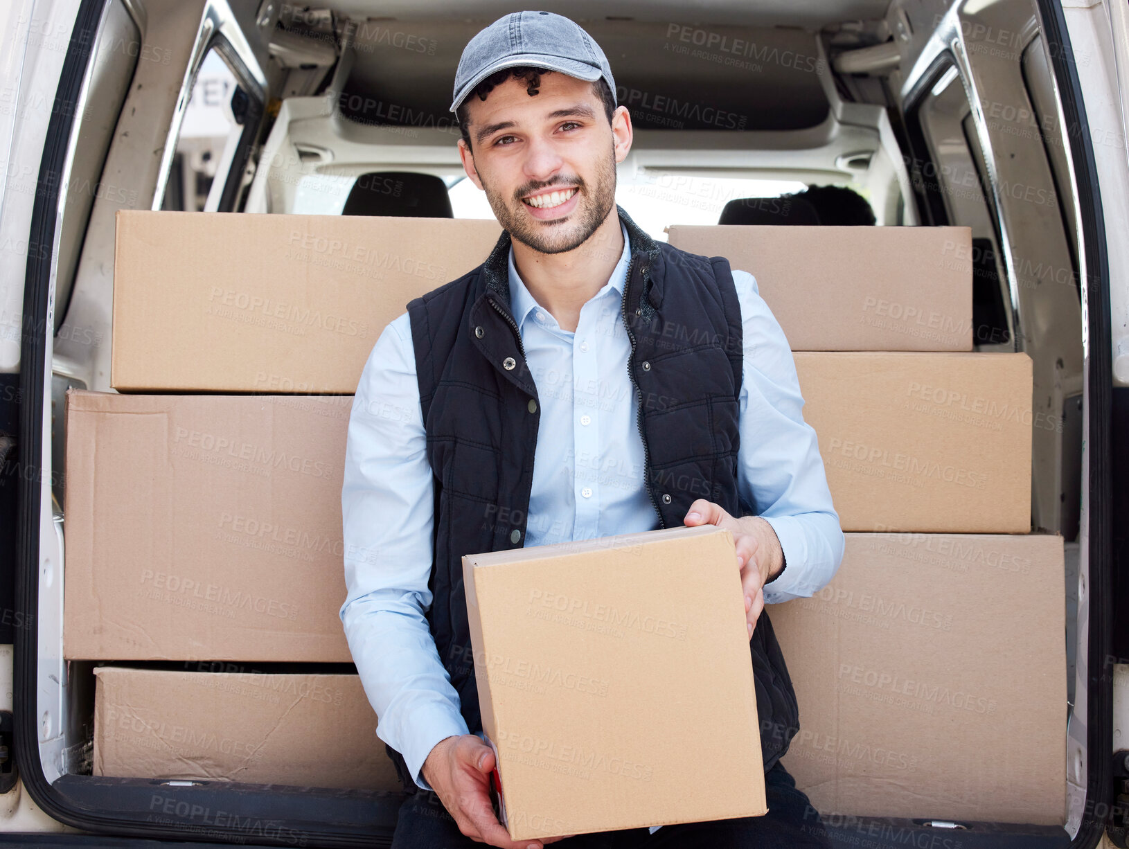 Buy stock photo Portrait of a young delivery man loading boxes from a van