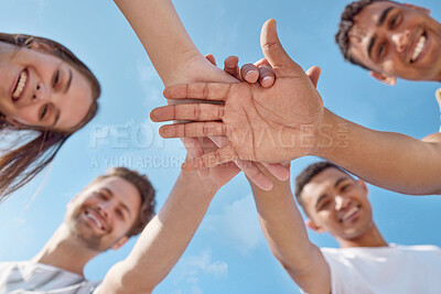 Buy stock photo Low angle shot of a group of young people stacking their hands