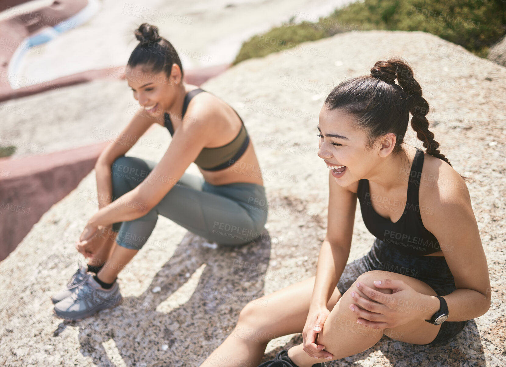 Buy stock photo High angle shot of two attractive athletic young women taking a break from their workout on the beach