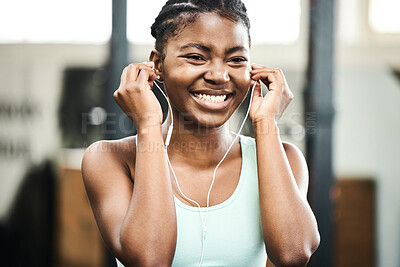 Buy stock photo Earphones, healthy and black girl in gym, music and listening for exercise, online and streaming on app. Fitness, audio and practice with technology, internet and radio for wellness and training