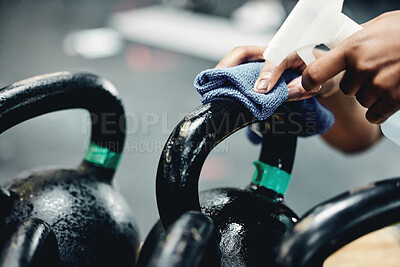 Buy stock photo Gym, cleaning or hand with sanitizer for kettlebell, safety or prevention or germs, virus and bacteria. Weights, spray or sports club janitor with dust cloth, liquid or hygiene of workout equipment