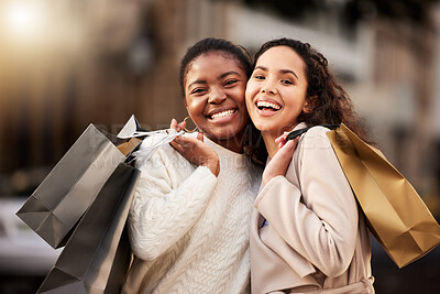 Buy stock photo Portrait of two young women shopping against an urban background
