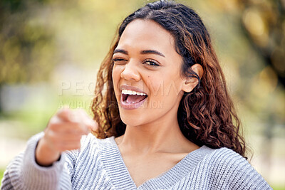 Buy stock photo Cropped portrait of an attractive young female student pointing towards the camera while standing outside on campus