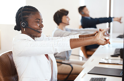 Buy stock photo Shot of a young call centre agent stretching her arms while working in an office