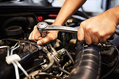 Buy stock photo Shot of an unrecognizable male mechanic working on the engine of a car during a service