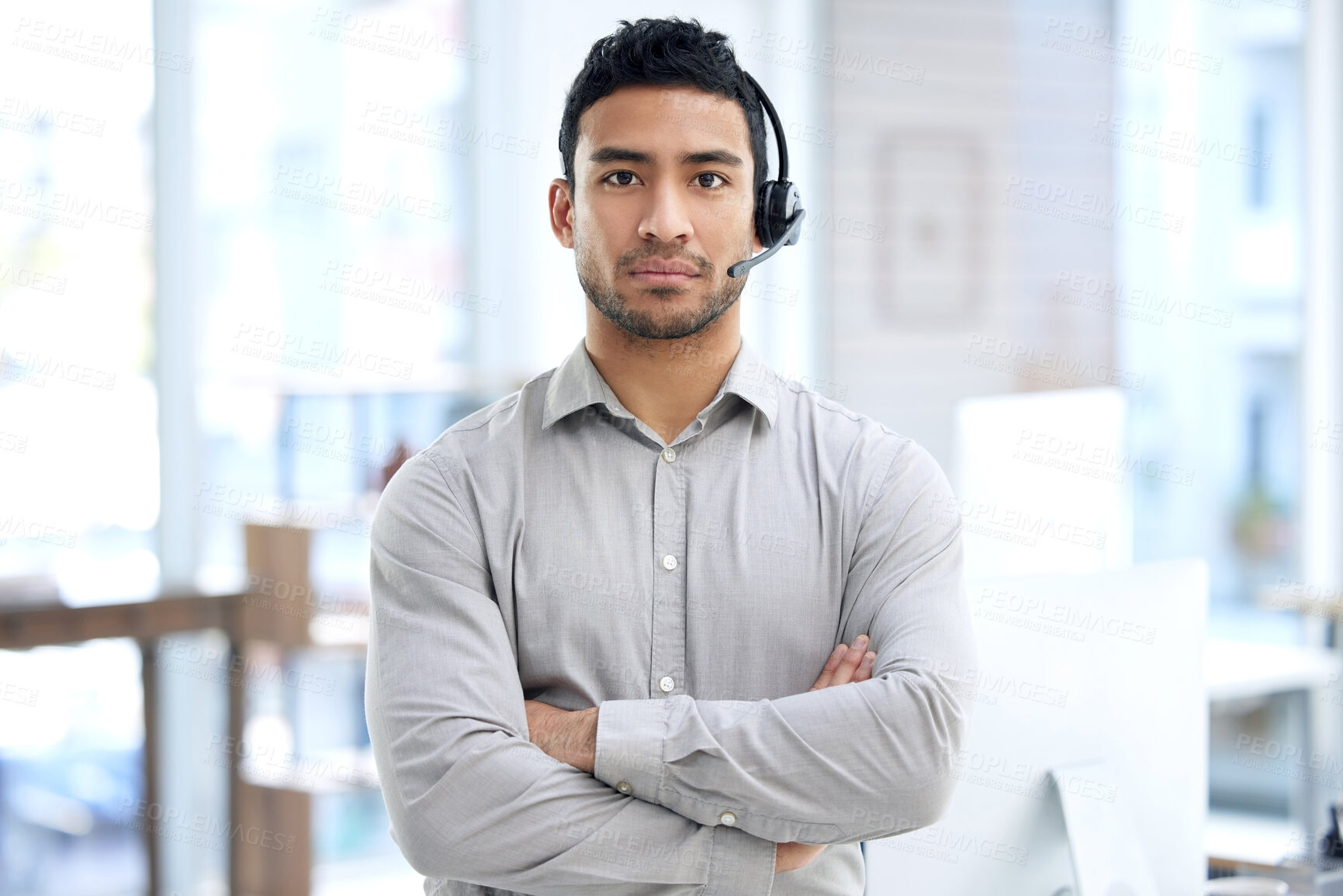 Buy stock photo Call center, man and portrait with arms crossed in office, telemarketing or serious face for crm job. Young indian consultant, voip headset and customer service for advice, sales or technical support