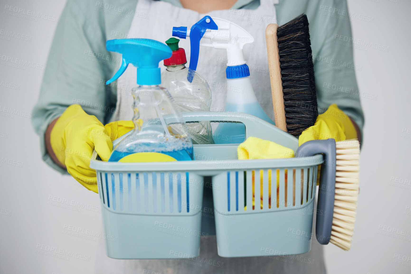 Buy stock photo Shot of a woman holding a basket with cleaning supplies