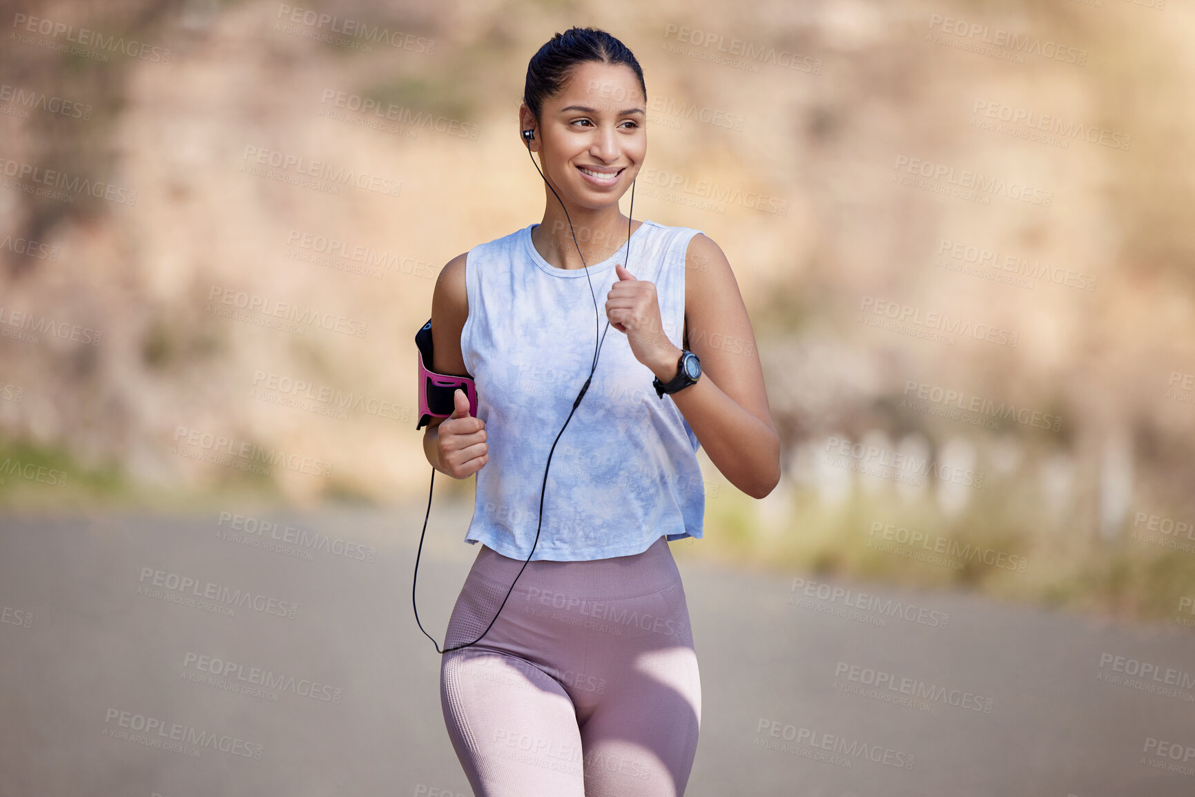 Buy stock photo Cropped shot of an attractive young female athlete enjoying a run outdoors