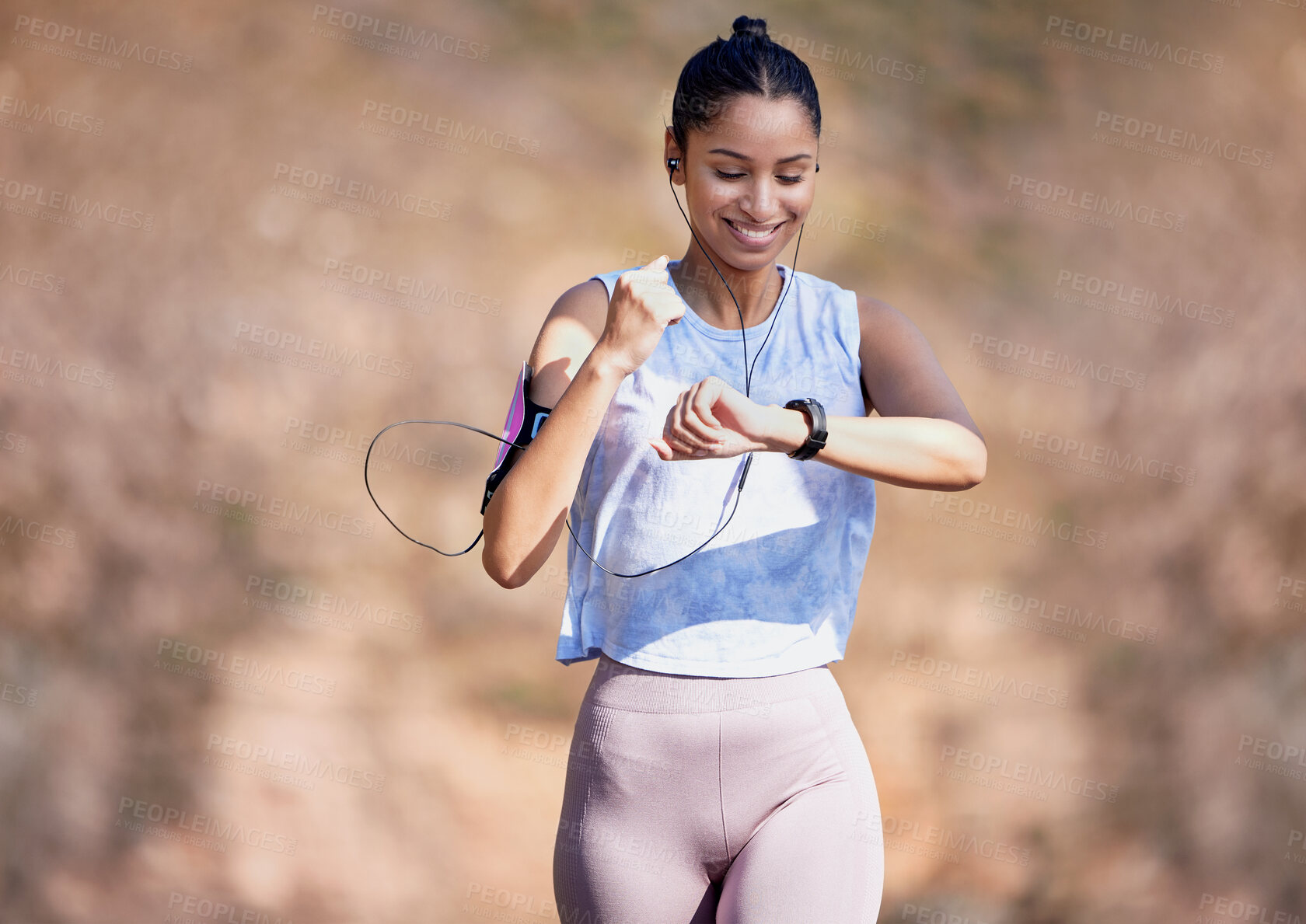 Buy stock photo Cropped shot of an attractive young female athlete checking her watch while running outside