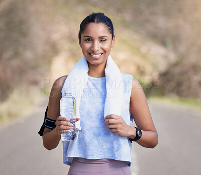 Buy stock photo Cropped portrait of an attractive young female athlete taking a break from her outdoor run to drink some water