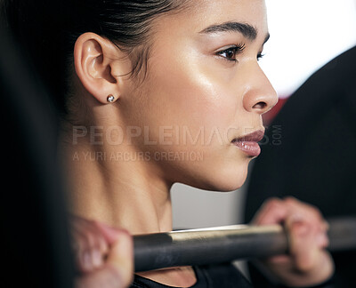 Buy stock photo Shot of a young woman working out with a barbell in a gym
