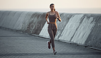 Buy stock photo Shot of a sporty young woman running outdoors