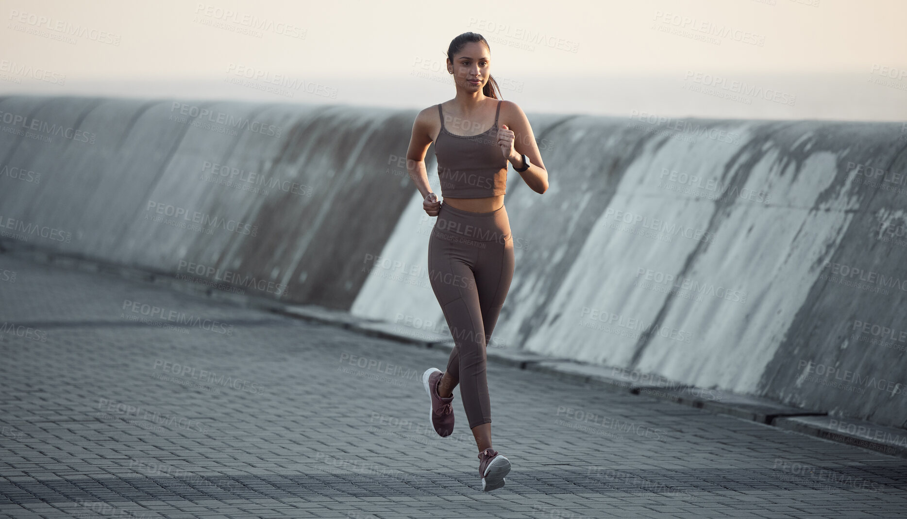 Buy stock photo Shot of a sporty young woman running outdoors