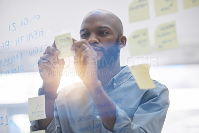 Buy stock photo Brainstorming, writing and business man on glass board for planning, schedule and scrum or agile solution. Thinking, ideas and focus of African person on window sticky notes, job priority or reminder