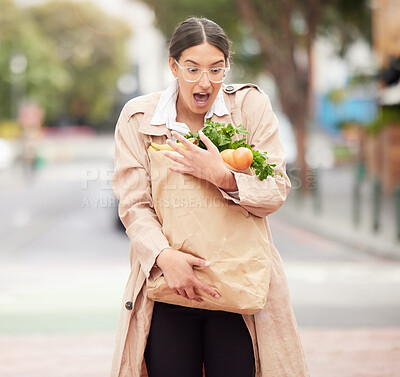 Buy stock photo Shot of a beautiful young woman trying to hold keep her groceries from falling from a broken paper bag