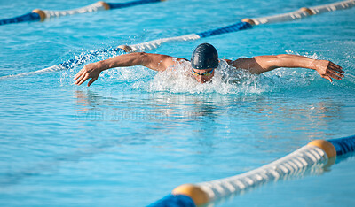 Buy stock photo Shot of a handsome young male athlete swimming in an olympic-sized pool