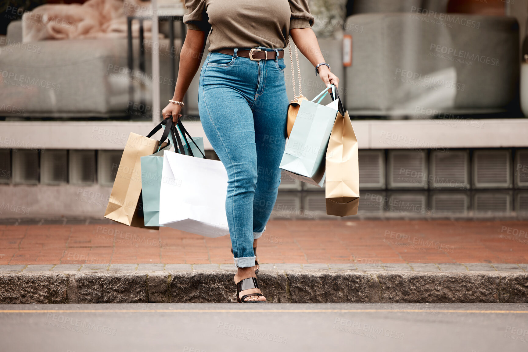 Buy stock photo Shot of an unrecognizable woman walking alone outside while shopping in the city