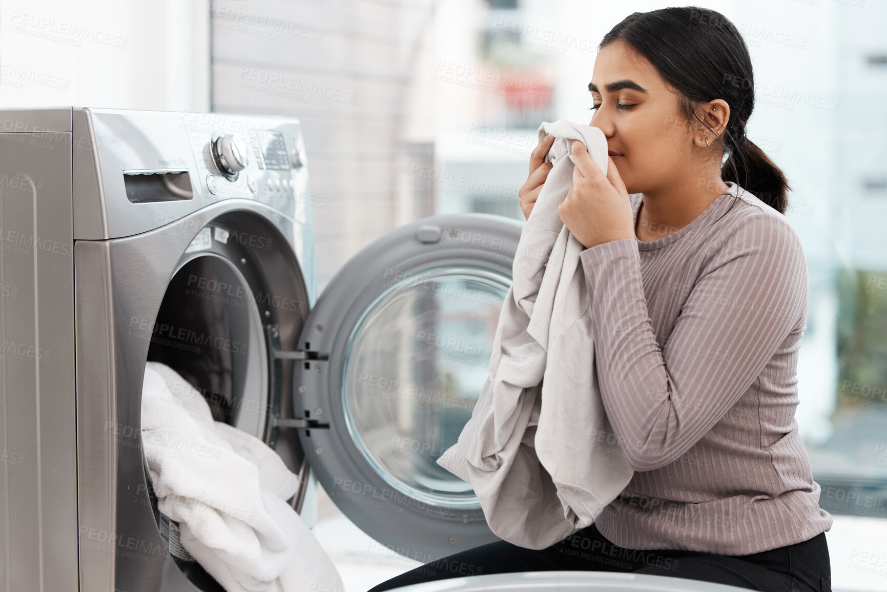 Buy stock photo Laundry, fresh scent and washing machine with woman smelling clothes in home for spring cleaning. Aroma, fabric and housework with person in apartment for domestic chores or weekend housekeeping