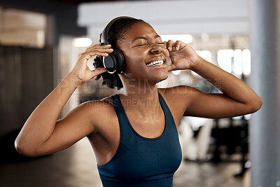 Buy stock photo Black woman, fitness and listening to music on headphones in workout, exercise or training at gym. Happy African female person or athlete enjoying audio sound track on headset for exercising indoors