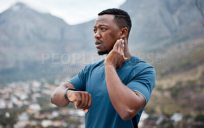 Buy stock photo Shot of a sporty young man checking his pulse while exercising outdoors