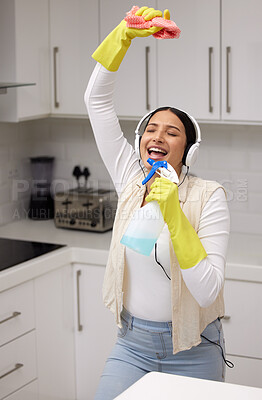Buy stock photo Woman with headphones, singing while cleaning and chemical bottle as mic with fun and music, hygiene and house work. Young female cleaner, housekeeping and enjoy listening to radio, dancing and clean