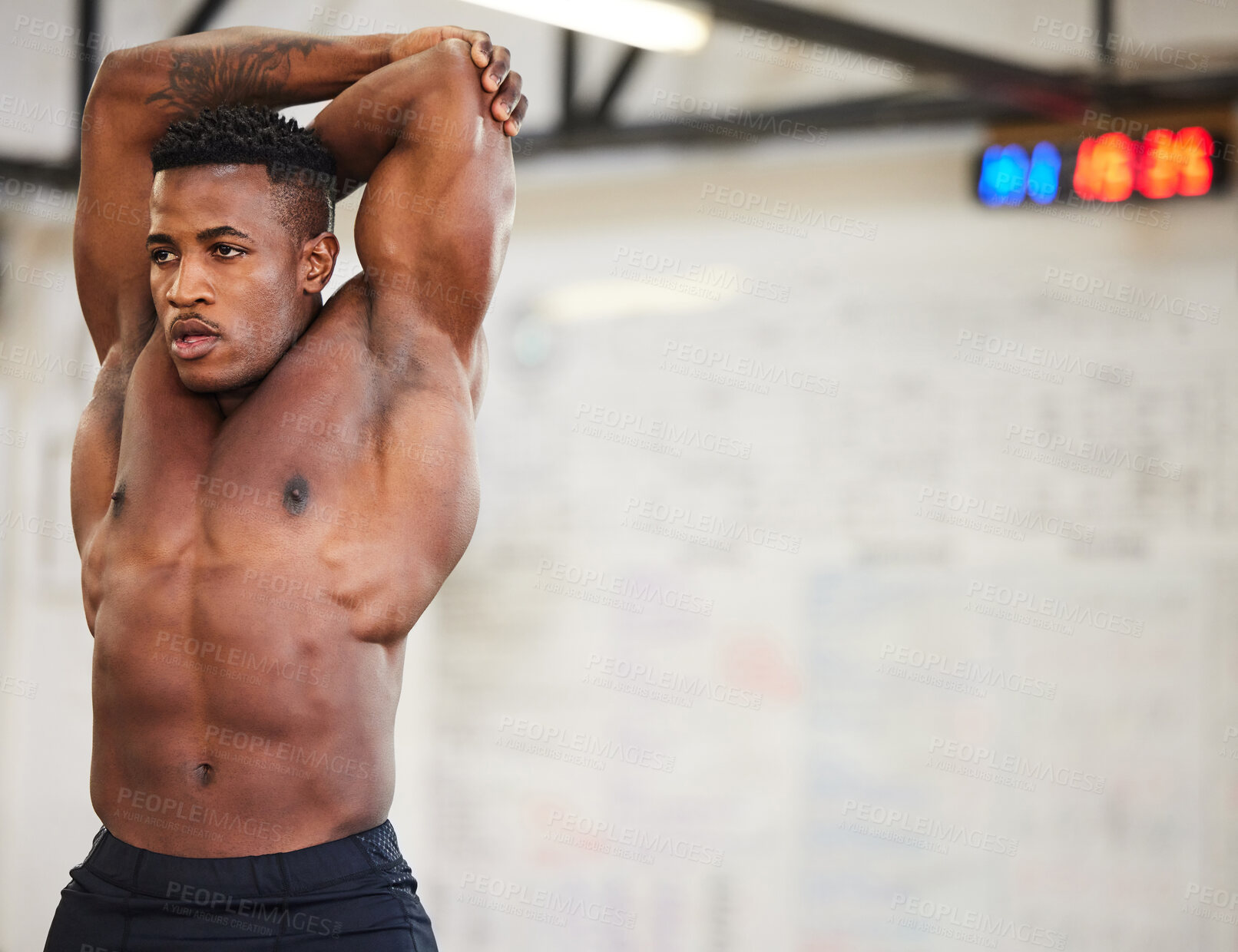 Buy stock photo Shirtless black man, stretching and fitness in gym with muscle, strong and abs with workout and mockup space. Serious male athlete, bodybuilder with warm up and ready for exercise with muscular arms