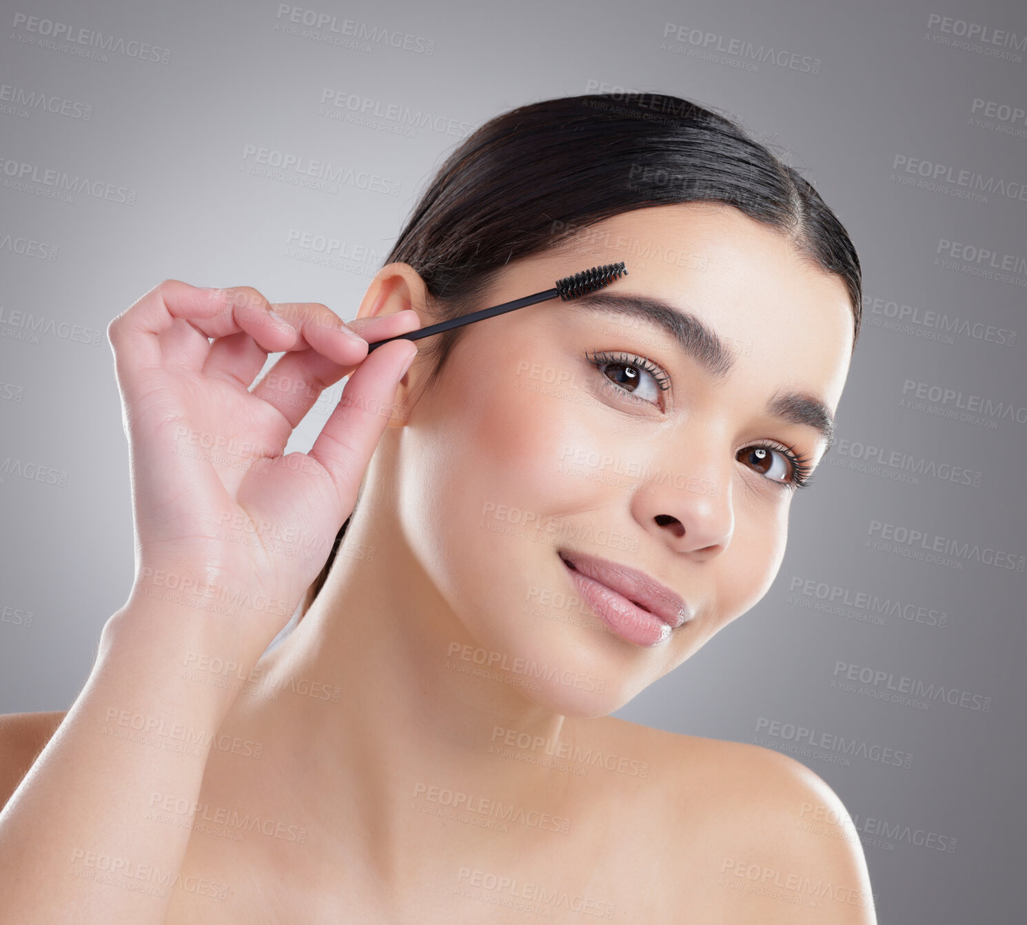 Buy stock photo Portrait, makeup and woman with mascara brush for beauty, skincare and shine isolated on grey studio background. Face, product and apply cosmetics on eyebrow for wellness, health or glow of model