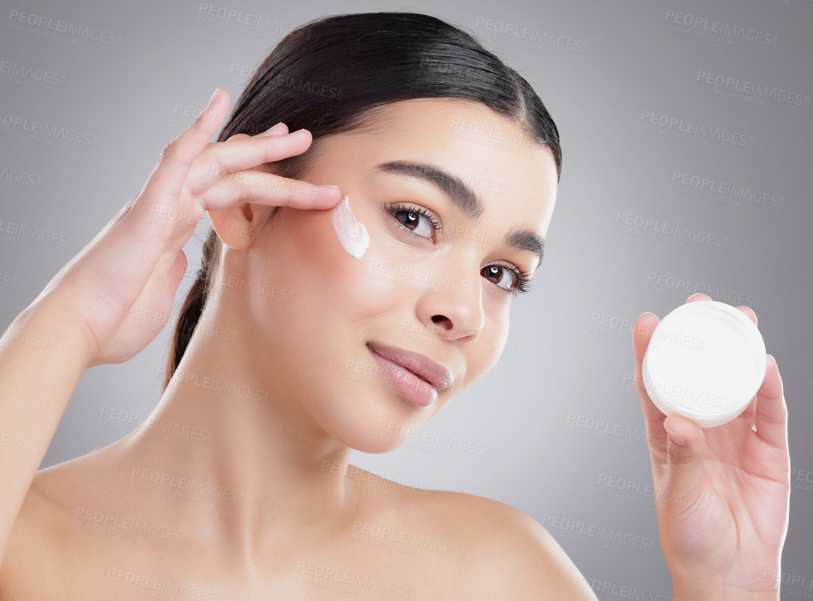 Buy stock photo Woman, portrait and apply cream in studio, sunscreen and skincare container on gray background. Female person, beauty and moisturizer jar for hydration, cosmetics and lotion treatment for dermatology