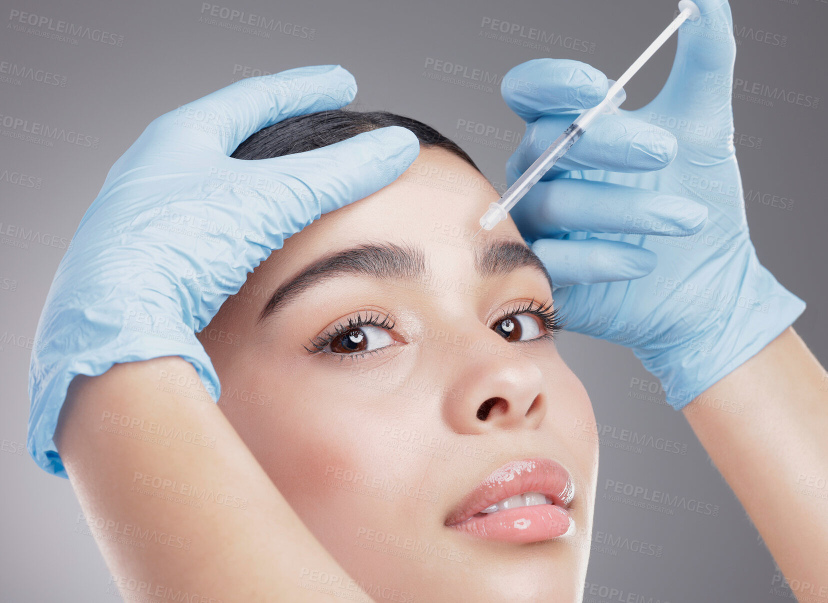 Buy stock photo Studio portrait of an attractive young woman having some plastic surgery done against a grey background