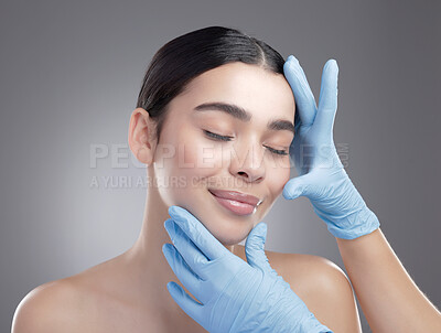 Buy stock photo Studio shot of an attractive young woman having some plastic surgery done against a grey background