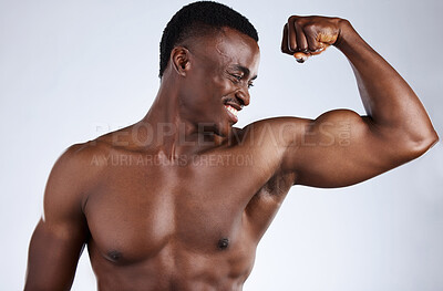 Buy stock photo Cropped shot of a handsome young musclar man flexing in studio against a grey background
