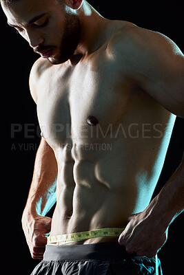 Buy stock photo Topless, fitness and man measuring waist in studio for progress, results or six pack on black background. Tape, goal or male bodybuilder with abs for strength, weight loss or improved physical health