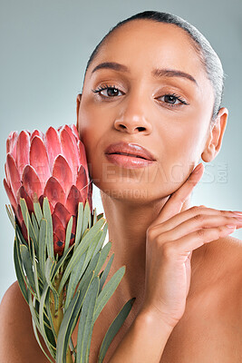 Buy stock photo Portrait, woman and skincare with flower in studio on white background for organic or natural treatment. Female person, confident and protea plant for skin glow, smooth and wellness or sustainability