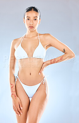 Buy stock photo Woman, portrait and bikini in studio for health or wellness, tattoo or fashion model with confidence. Female person, blue background and underwear with relax for fitness, transformation or motivation
