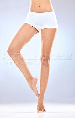 Buy stock photo Woman, legs and skincare with underwear in epilation, hair removal or grooming on a blue studio background. Closeup of female person, feet or beauty for laser treatment, cosmetology or dermatology