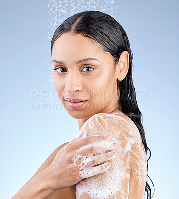 Buy stock photo Studio portrait of an attractive young woman taking a shower against a blue background