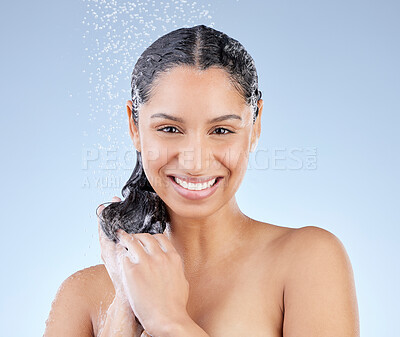 Buy stock photo Studio portrait of an attractive young woman taking a shower against a blue background