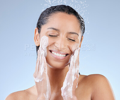 Buy stock photo Studio shot of an attractive young woman taking a shower against a blue background