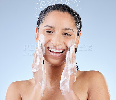 Buy stock photo Studio portrait of an attractive young woman taking a shower against a blue background